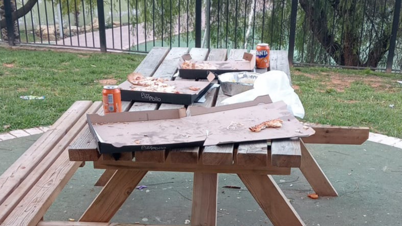 Basura en el c&eacute;sped y mobiliario arrancado en un parque de Arahal.